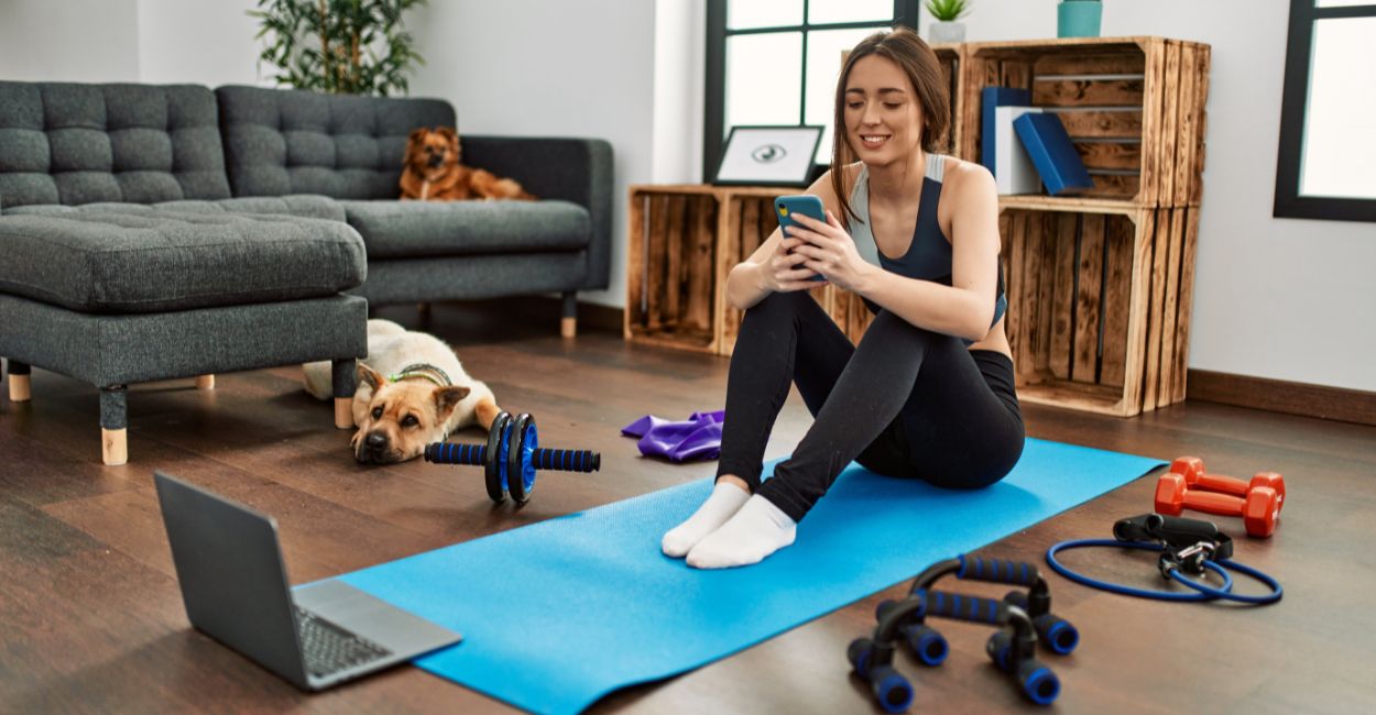 Mulher treinando em casa com aplicativo fitness e acessórios simples